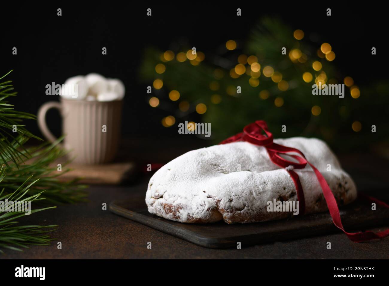 Corde de Noël traditionnelle décorée de Noël sur une table festive avec guirlande, tasse de café et branches de pin à feuilles persistantes. Salon de Noël Banque D'Images