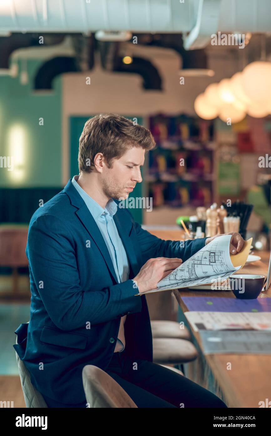 Jeune homme d'affaires regardant le plan de construction Banque D'Images