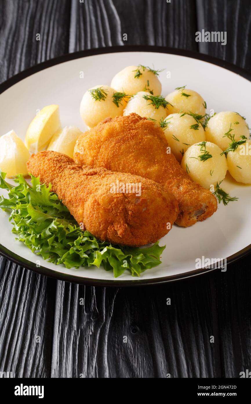 Poulet frit viennois Wiener Backhendl préparé et épicé portions de poulet, panées et croustillantes frites profondes servies avec du citron et du potatoe Banque D'Images