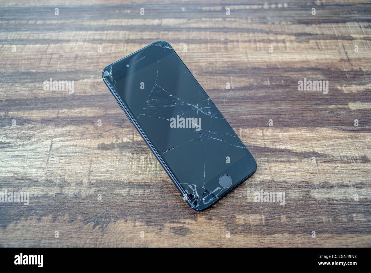 PARIS, FRANCE - 12 septembre 2021 : gros plan de l'écran en verre cassé d'un smartphone iPhone 7 sur une table en bois Banque D'Images