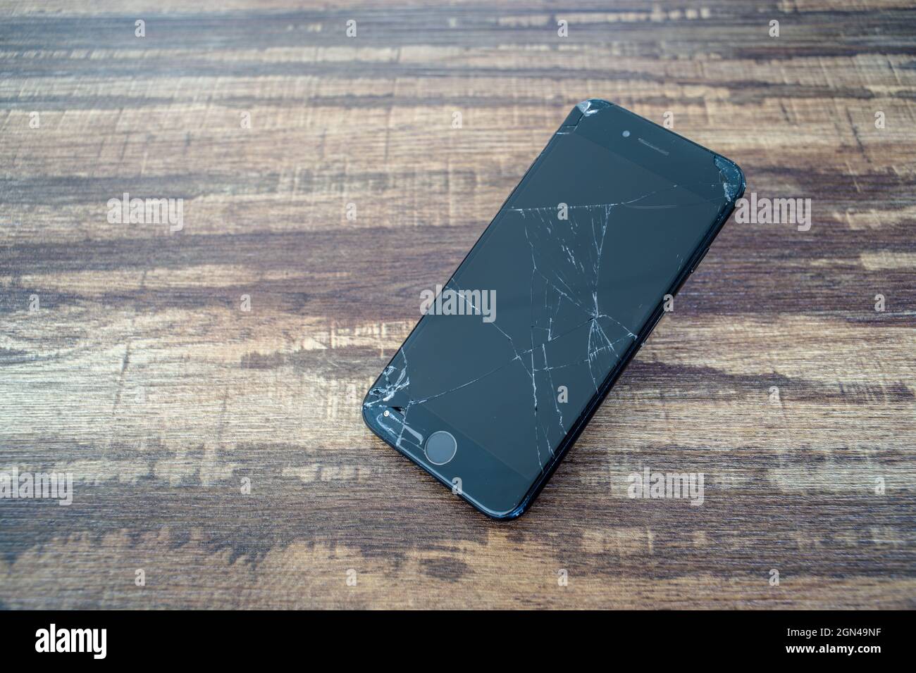 PARIS, FRANCE - 12 septembre 2021 : gros plan de l'écran en verre cassé d'un smartphone iPhone 7 sur une table en bois Banque D'Images
