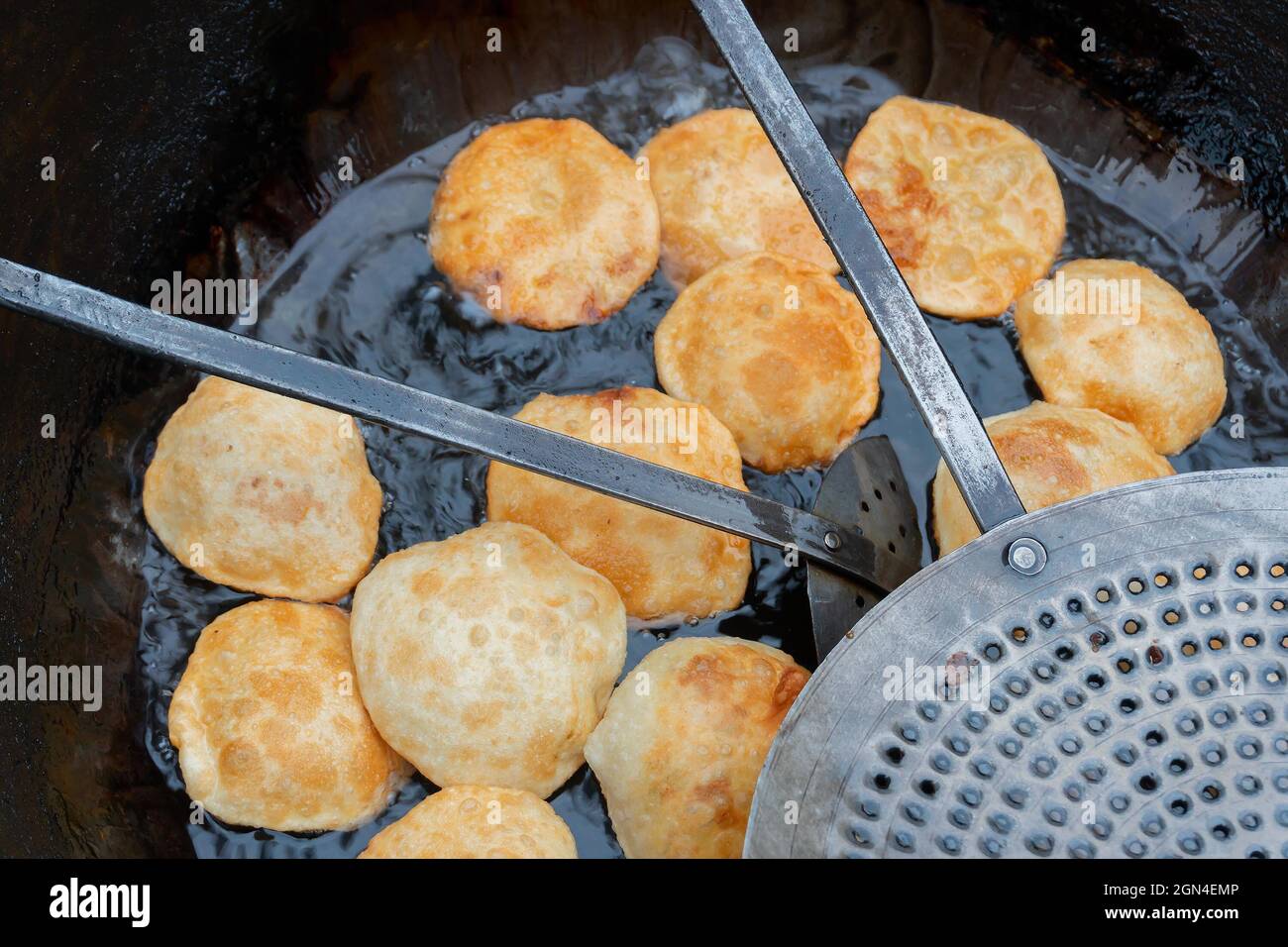 Les Kochuris sont frits dans une poêle. Kochuri, kachori de kachauri est une collation épicée, des boulettes frites et une cuisine de rue très populaire en Inde. Banque D'Images