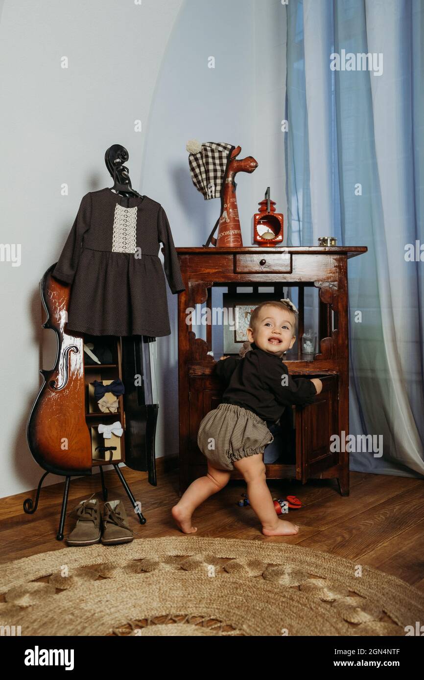 Mignon petite fille de bébé en vêtements vintage jouant à la maison. Mode  de bébé sans sexe. Vêtements unisexe pour enfants. Petite petite fille en  vert et Photo Stock - Alamy