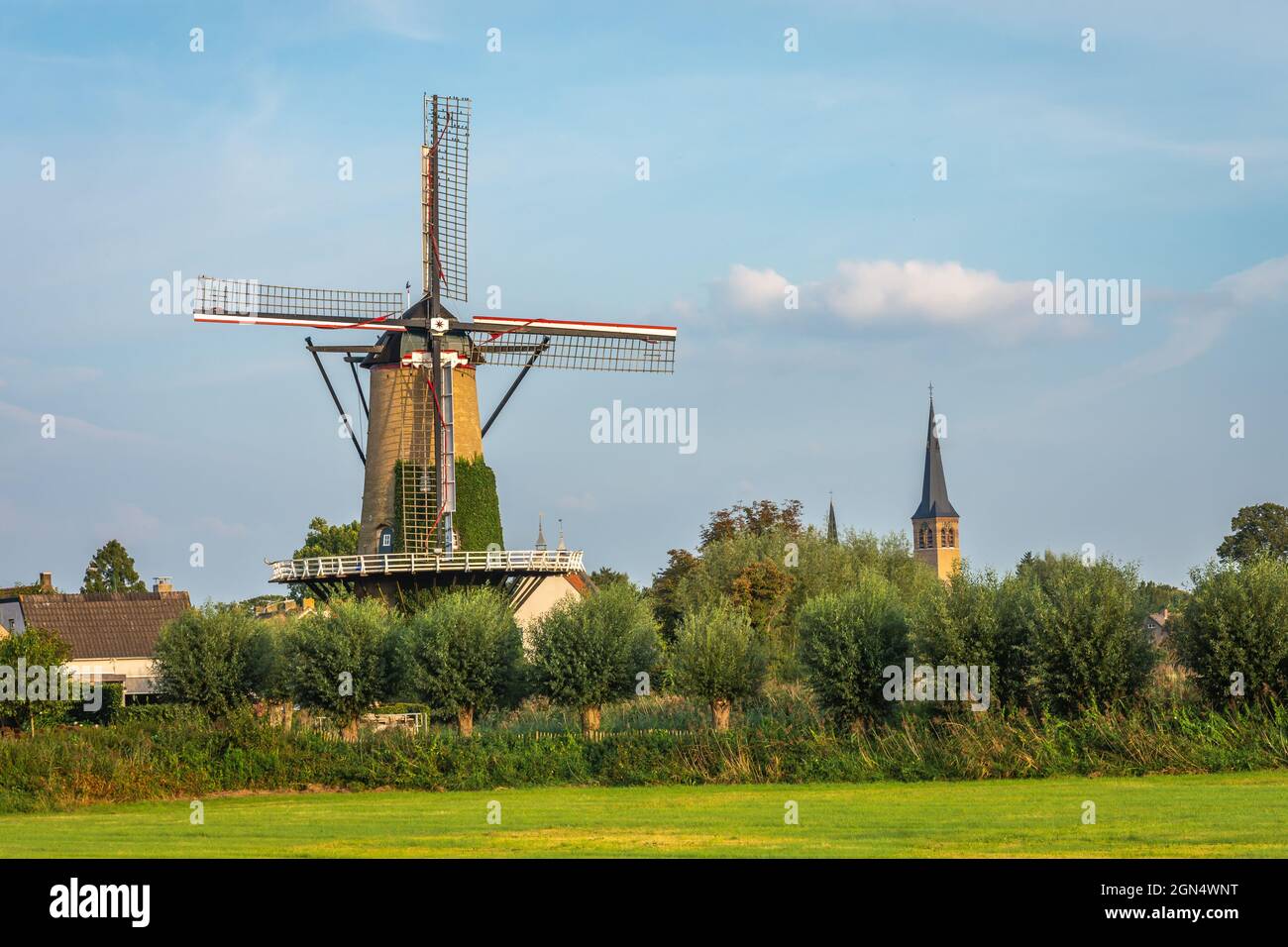 Paysage hollandais typique avec moulin à vent traditionnel à côté de la tour de l'église dans le village de Terheijden, Brabant Nord Banque D'Images