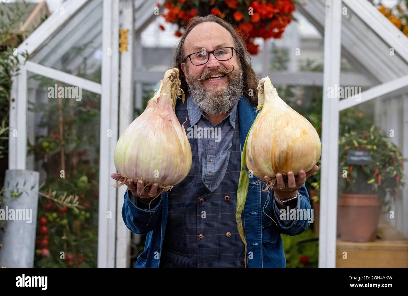 Dave Myers, présentateur de télévision et moitié des Hairy Bikers, au RHS Chelsea Flower Show.Il tient deux très gros oignons. Banque D'Images