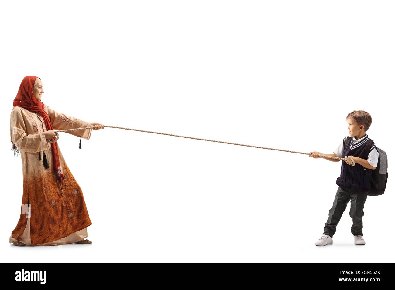 Photo pleine longueur d'un garçon d'école et d'une femme portant un hijab tirant une corde isolée sur fond blanc Banque D'Images