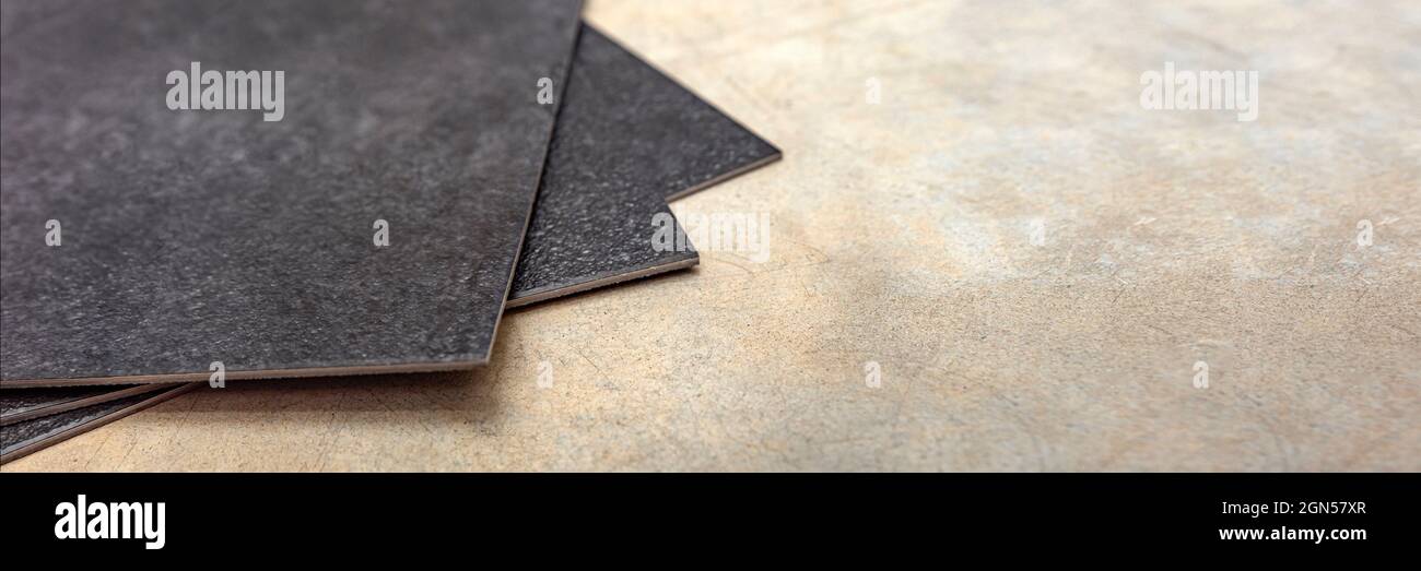 Plancher en PVC vinyle. La texture du plancher en vinyle est noire. Échantillons de revêtement en vinyle, carreaux en pvc noir sur sol en béton avant l'installation. Banque D'Images