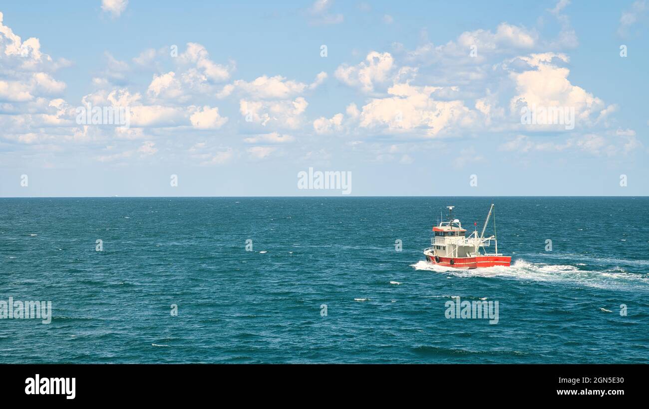 Istanbul, Turquie - août 2021 : bateau de pêche naviguant dans des eaux ouvertes, loin dans un paysage marin. Banque D'Images