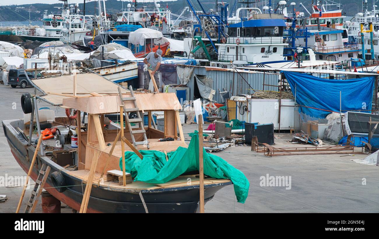 Rumeli Feneri, Istanbul, Turquie - août 2021 : homme réparant un bateau de pêche dans le port de Rumeli Feneri dans le district de Sariyer. Banque D'Images