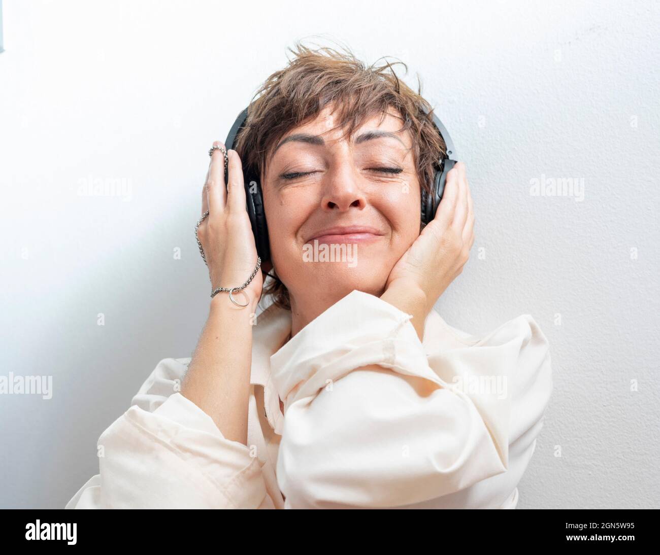 Une femme excitée écoute de la musique avec son casque. Histoire d'amour. Bague d'engagement Banque D'Images