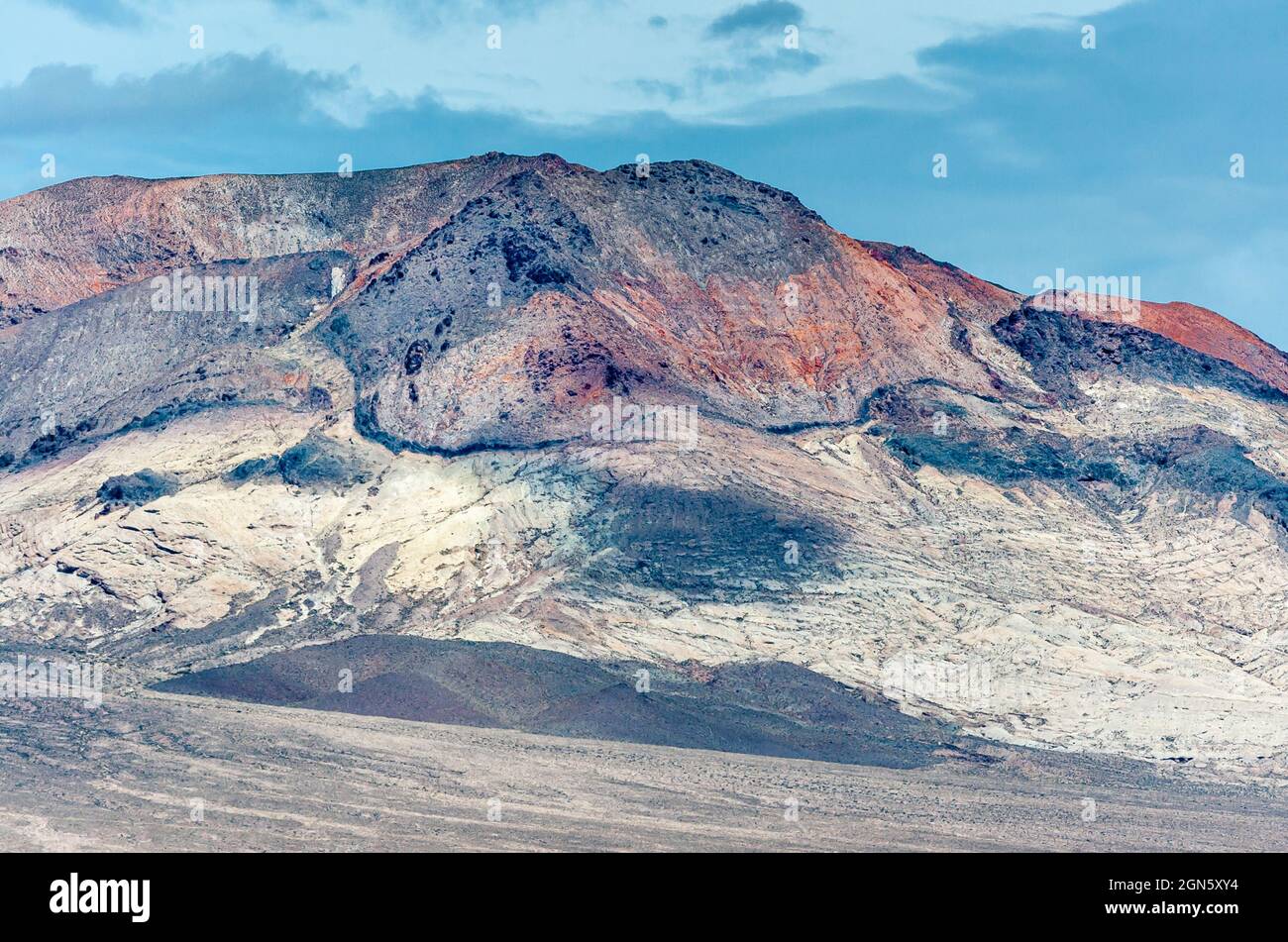 High Desert, Nevada, USA - 17 mai 2011: Gros plan de haute montagne riche en minéraux et colline noire sous bleu ciel nuageux. Banque D'Images