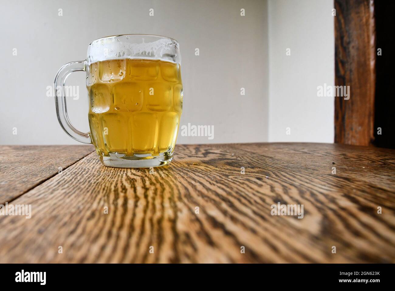 Tasse à bière avec bière pression sur une table rustique ; désaltérant alcoolique par temps chaud. Banque D'Images
