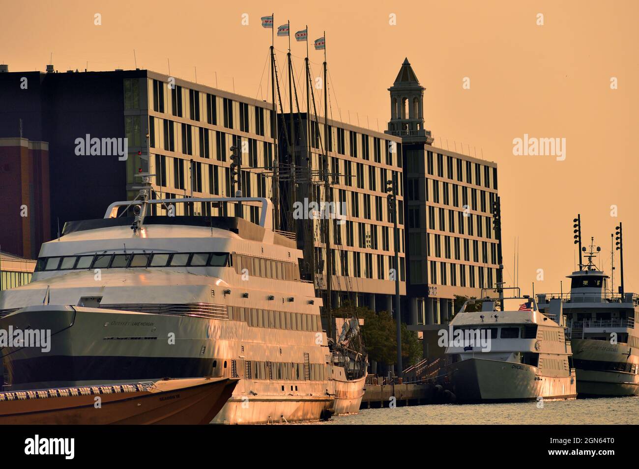 Chicago, Illinois, États-Unis. Les navires arriés à l'embarcadère Navy Pier de Chicago reflètent une lueur douce peu de temps après le lever du soleil en fin de matinée d'été. Banque D'Images