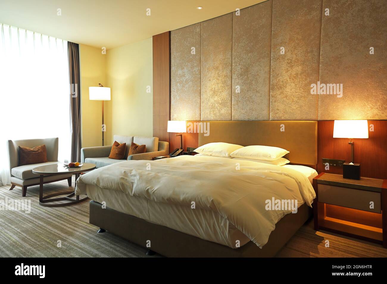 Chambre moderne chaleureuse et confortable, grande fenêtre avec canapé et table. Banque D'Images