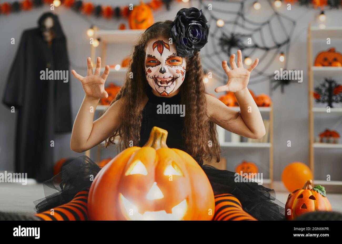 Portrait d'une petite fille dans un costume effrayant et maquillage de crâne à une fête d'Halloween Banque D'Images