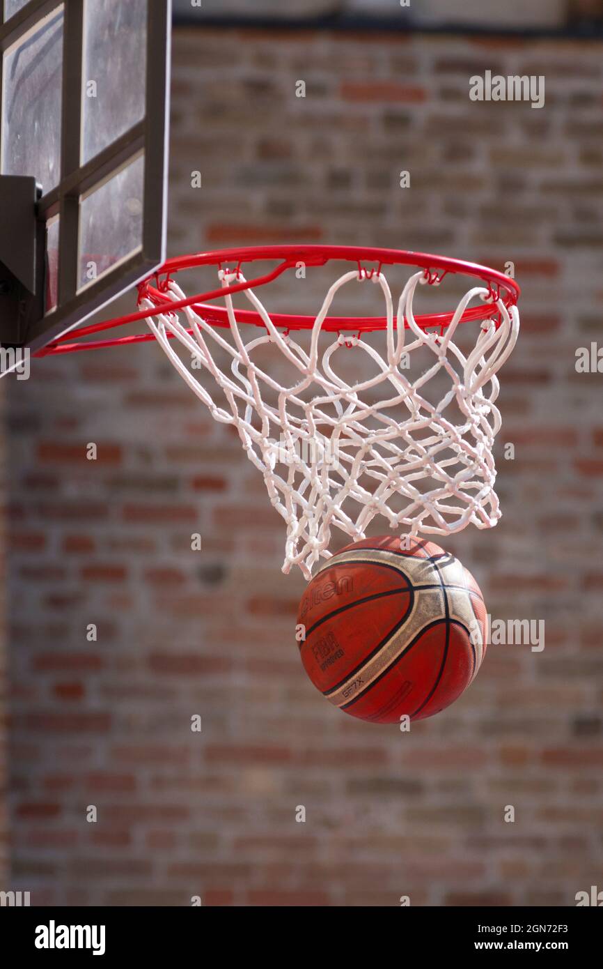 Basket-ball Ring le ballon tombe à travers le Hoop Banque D'Images