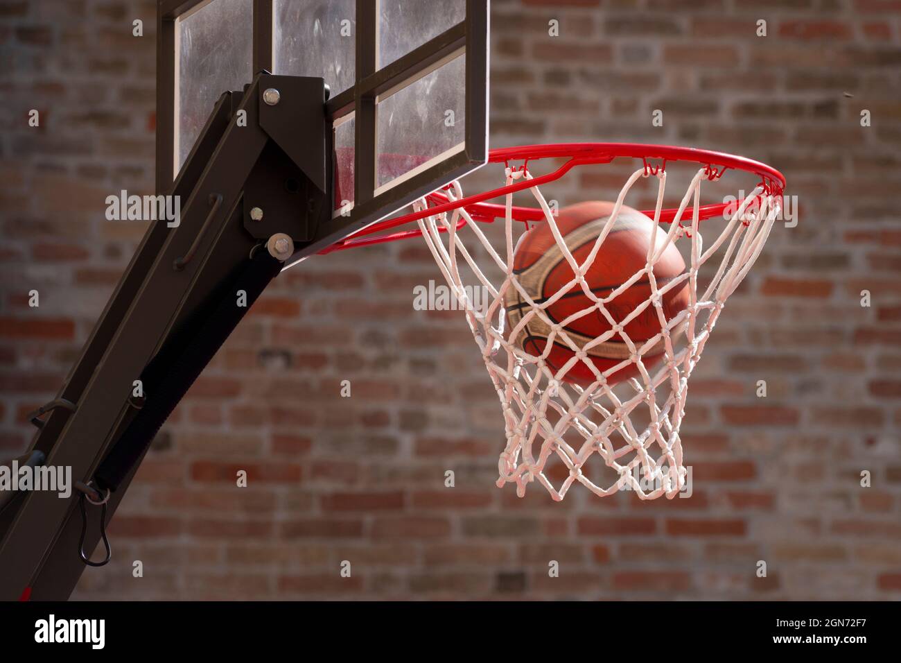 Basket-ball Ring le ballon tombe à travers le Hoop Banque D'Images