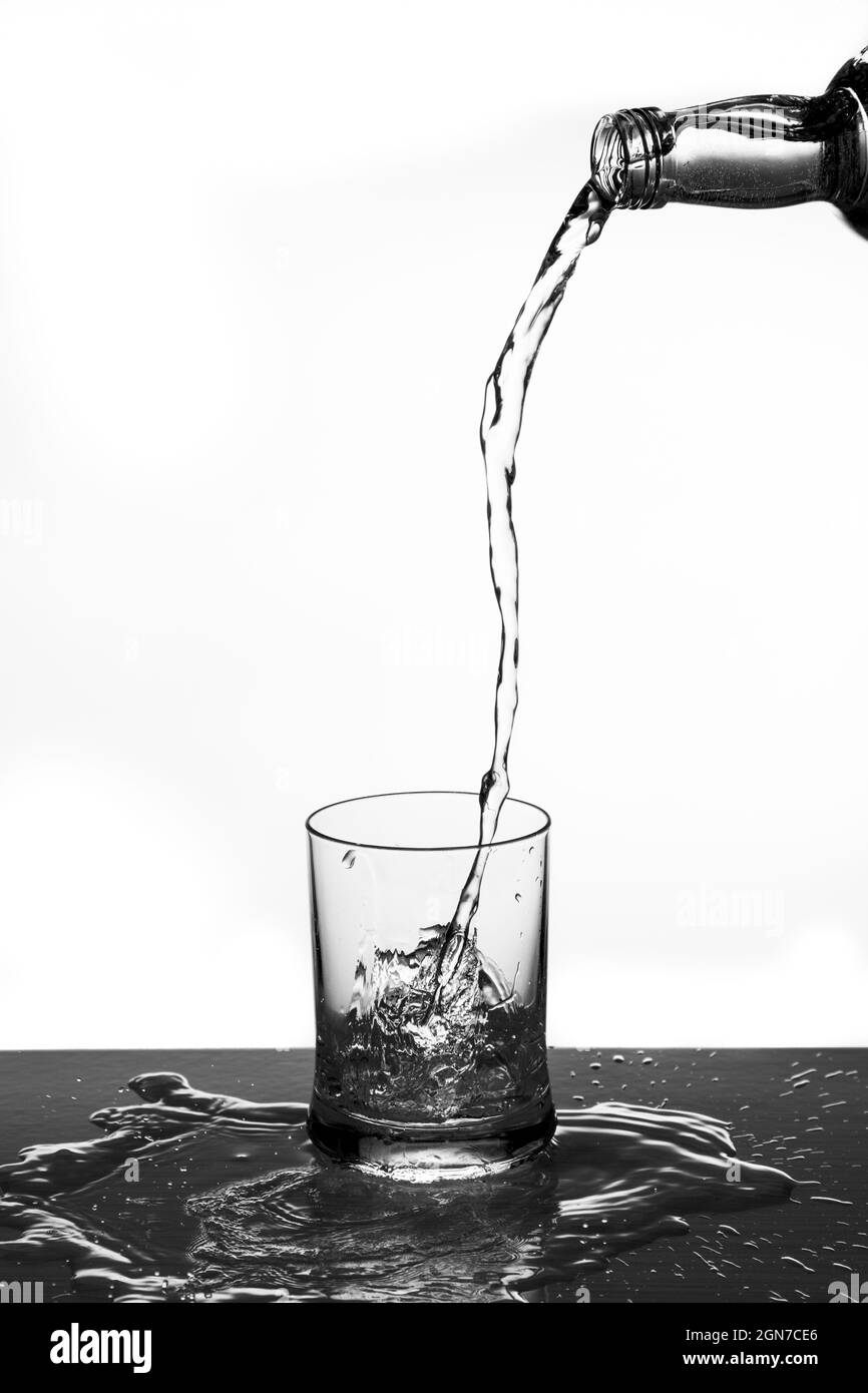 Verser de l'eau dans un gobelet en verre Banque D'Images