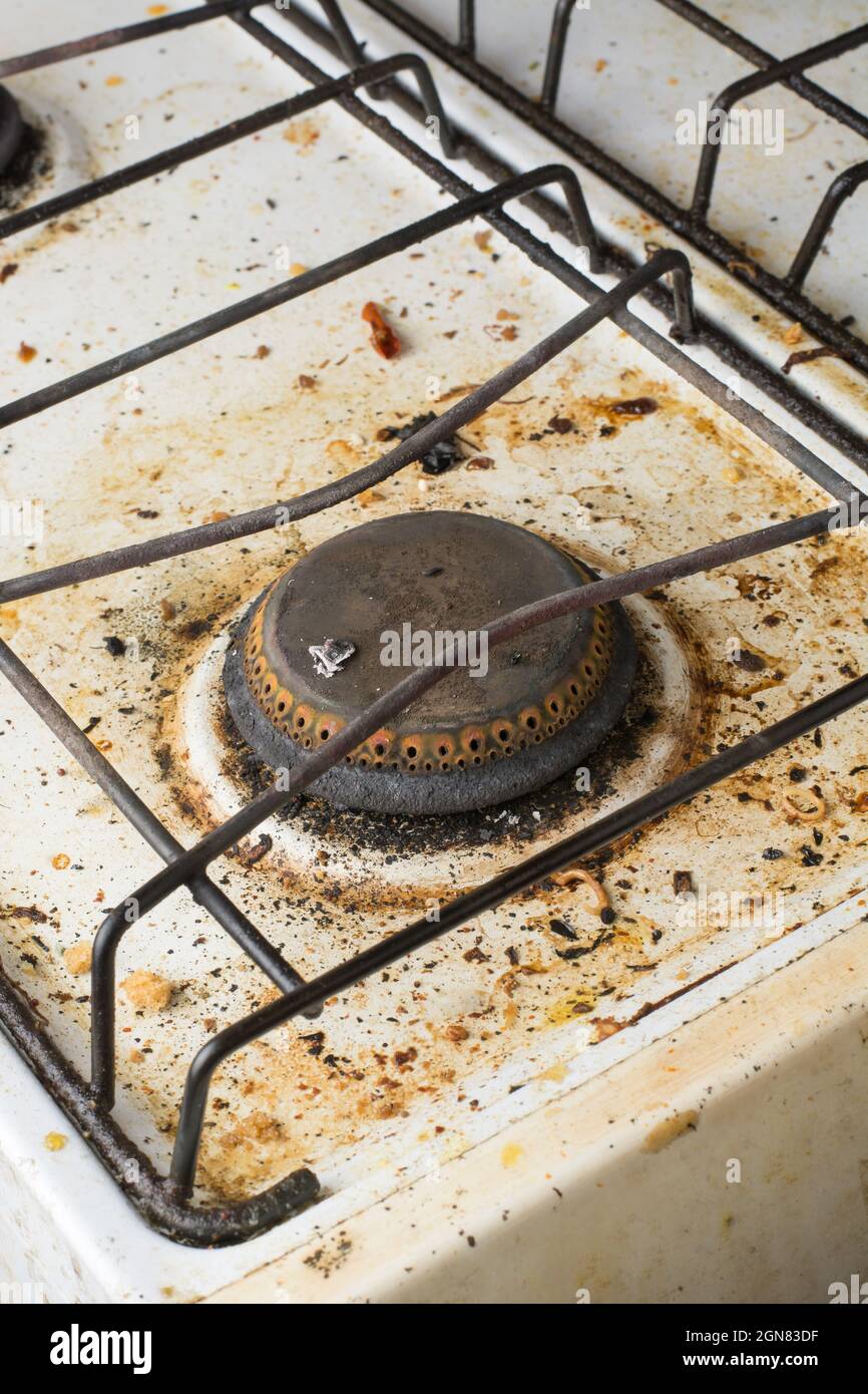 une cuisinière sale ou cuisinière à gaz dans la cuisine, surface couverte de taches avec des restes de nourriture, brûleur non nettoyé fermé Banque D'Images