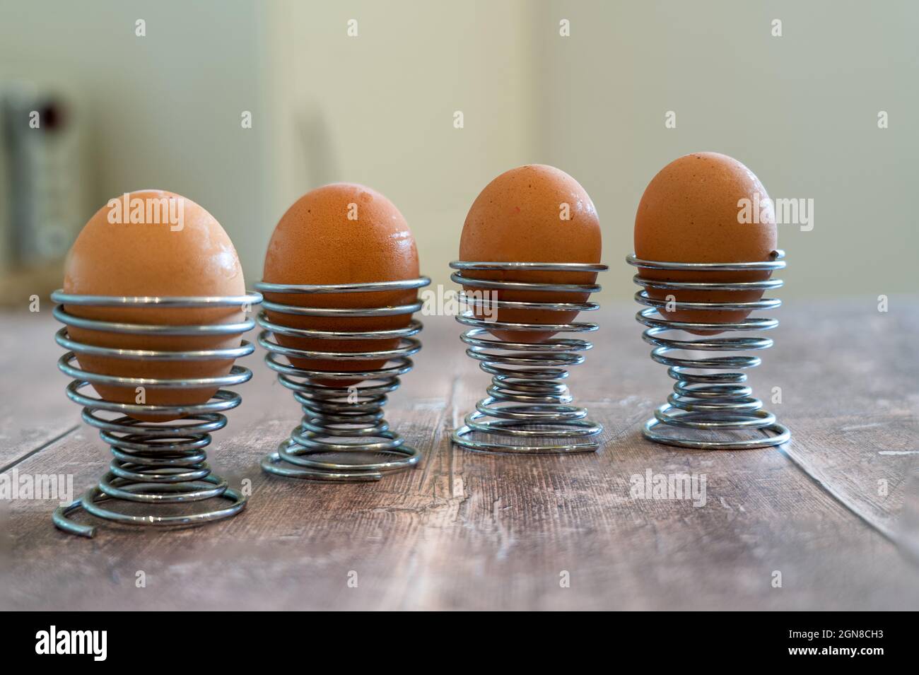 Quatre œufs en acier inoxydable spirale porte-gobelets à œufs isolés sur  une table rustique en bois Photo Stock - Alamy