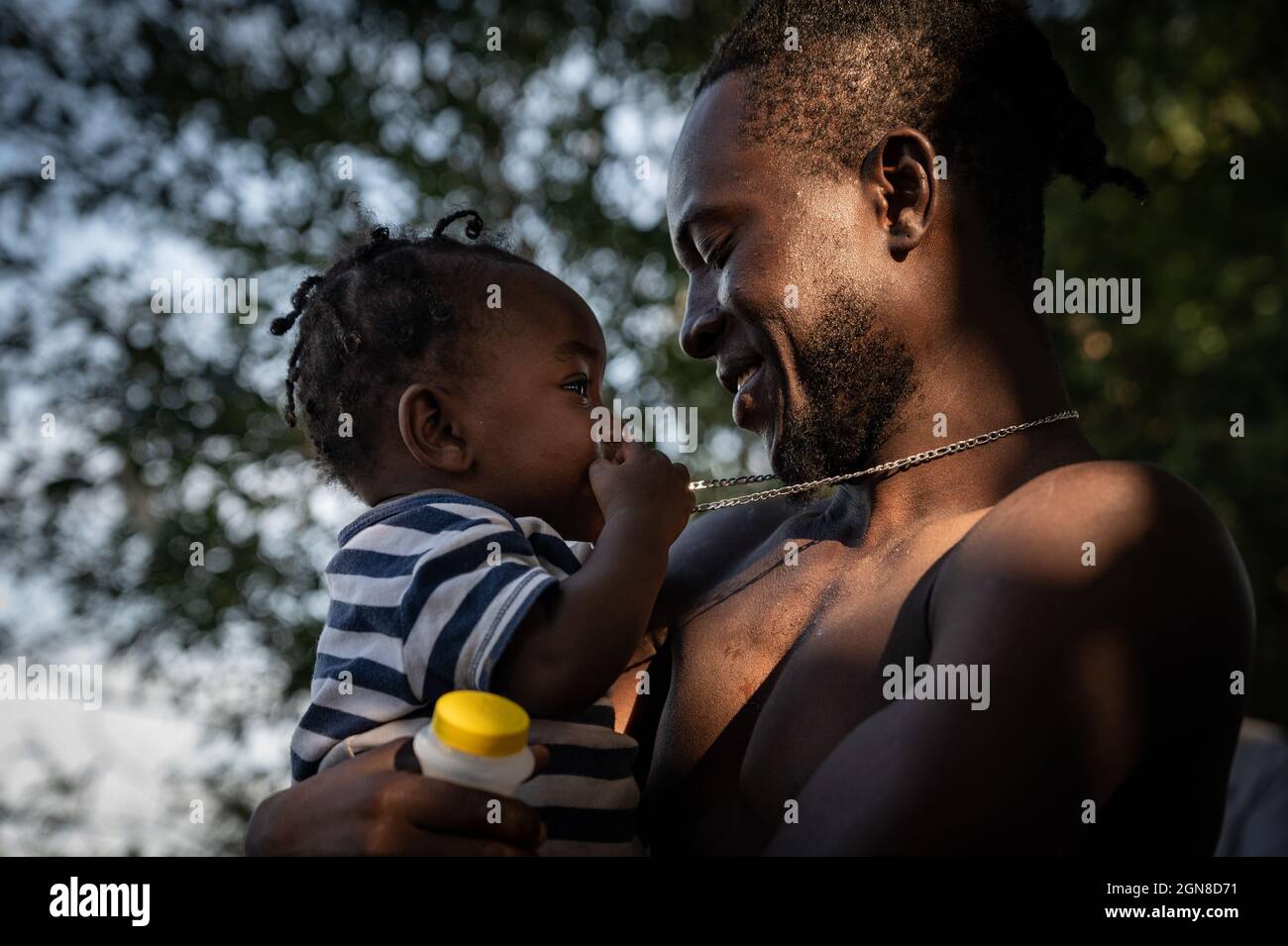 22 septembre 2021, Acuña, Coahuila de Zaragoza, Mexique: Le père migrant joue avec son fils en attendant de traverser le Rio Grande du Mexique vers les États-Unis où près de 10,000 migrants sont détenus. (Credit image: © Raquel Natalicchio/ZUMA Press Wire) Banque D'Images