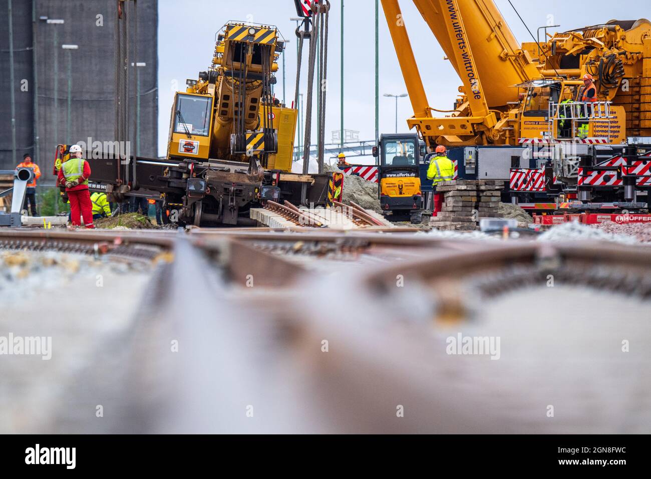 Emden, Allemagne. 23 septembre 2021. Des grues montées sur camion sont utilisées pour lever une grue de construction de rail déraillée pesant plus de 100 tonnes. La grue de construction ferroviaire a déraillé la semaine dernière au quai de Borkum et doit maintenant être récupérée. Credit: Sina Schuldt/dpa/Alay Live News Banque D'Images