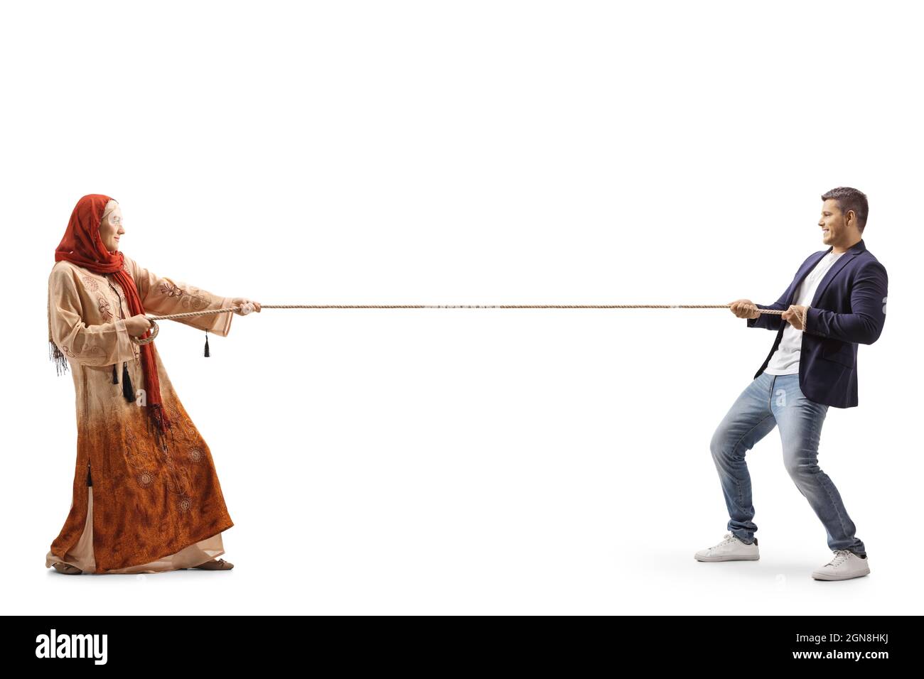 Photo pleine longueur d'un homme décontracté et d'une femme portant un hijab tirant une corde isolée sur fond blanc Banque D'Images