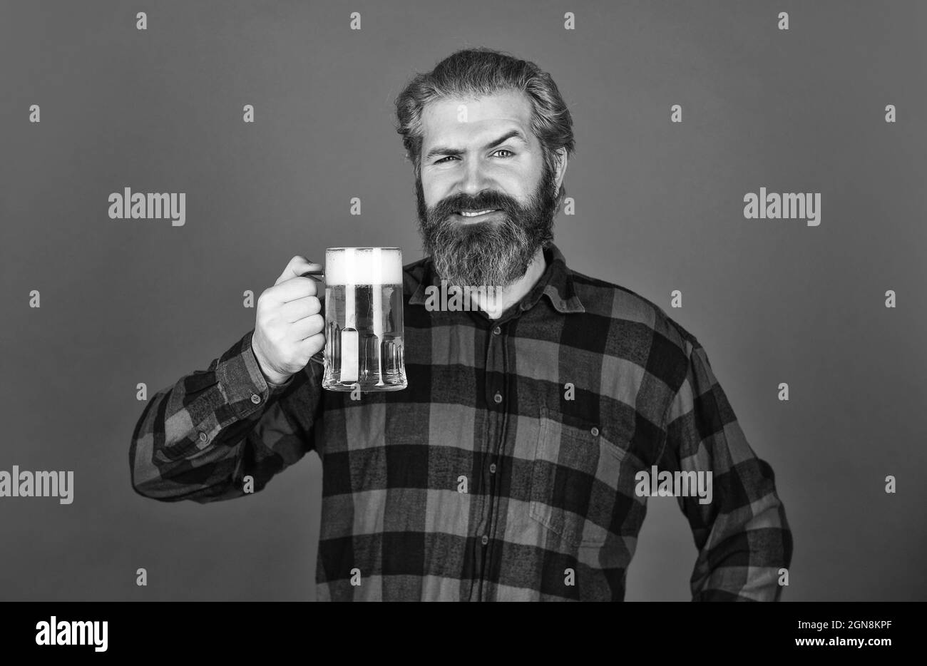 Oktoberfest. Brasserie. Barman ou barman élégant au bar. Loisirs. Un homme tient un verre de bière. un boxeur au comptoir du bar. S'amuser à regarder le football Banque D'Images