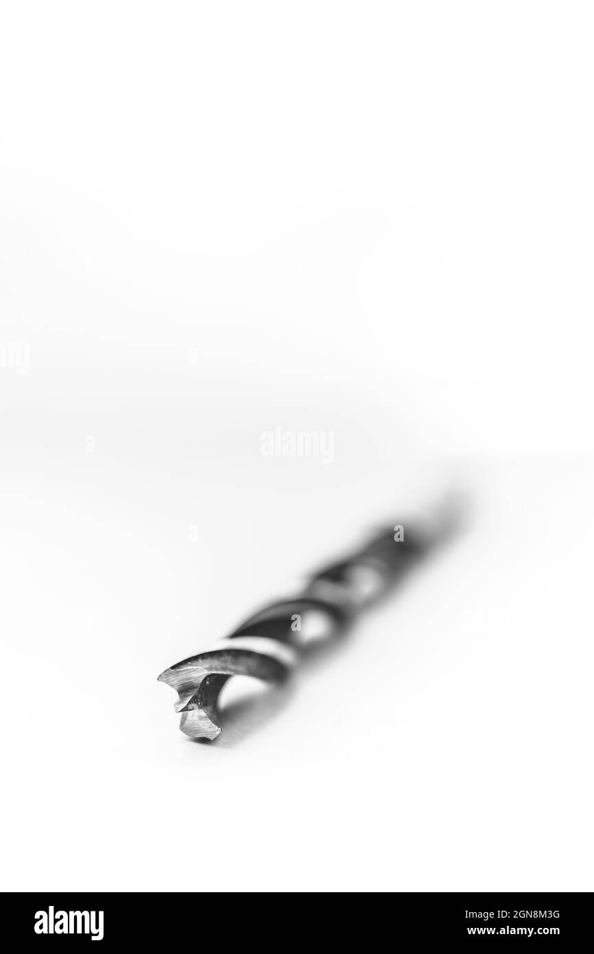 Un portrait en studio noir et blanc d'un foret en acier haute vitesse en spirale sur fond blanc. L'outil métallique est utilisé pour percer des trous dans le bois f Banque D'Images
