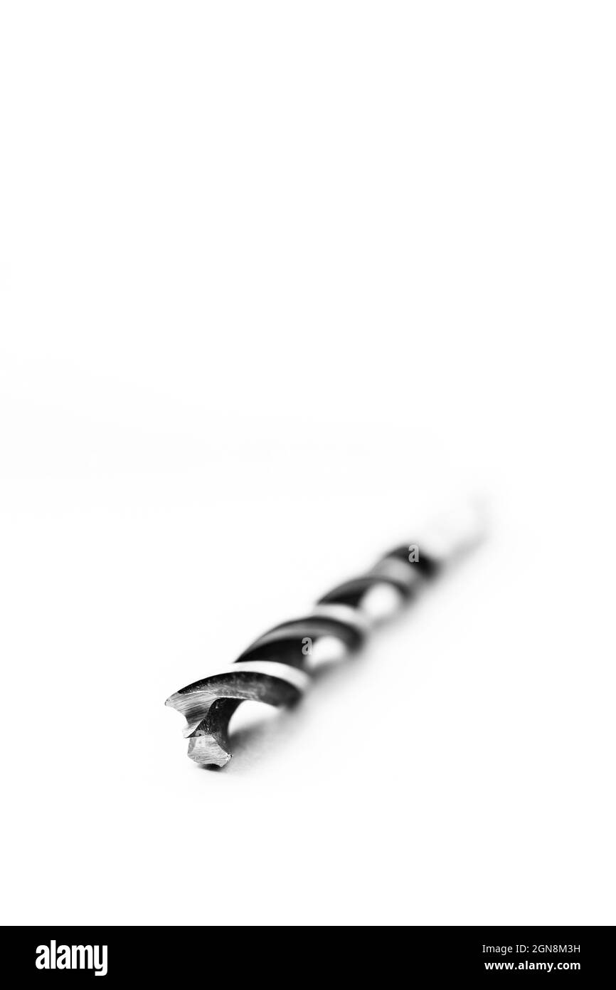Un portrait en studio noir et blanc d'un foret en acier haute vitesse en spirale sur fond blanc. L'outil métallique est utilisé pour percer des trous dans le bois f Banque D'Images