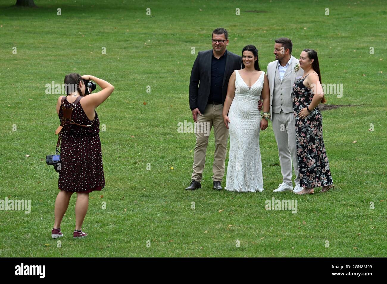 Photographe prenant des photos d'un couple de mariage avec leurs groommen Banque D'Images