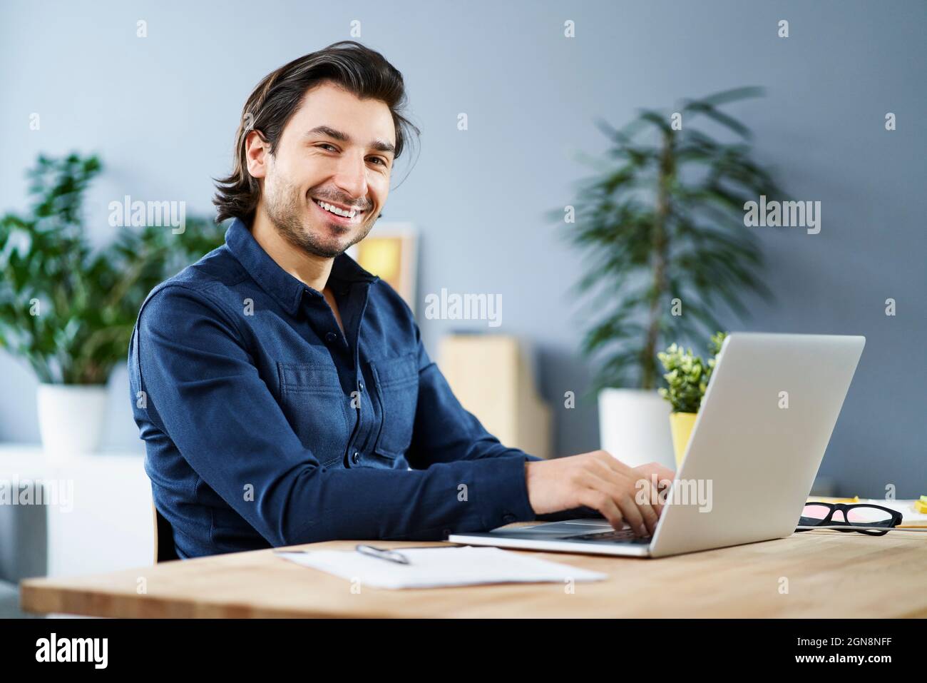 Travailleur indépendant avec ordinateur portable sur le bureau à domicile Banque D'Images