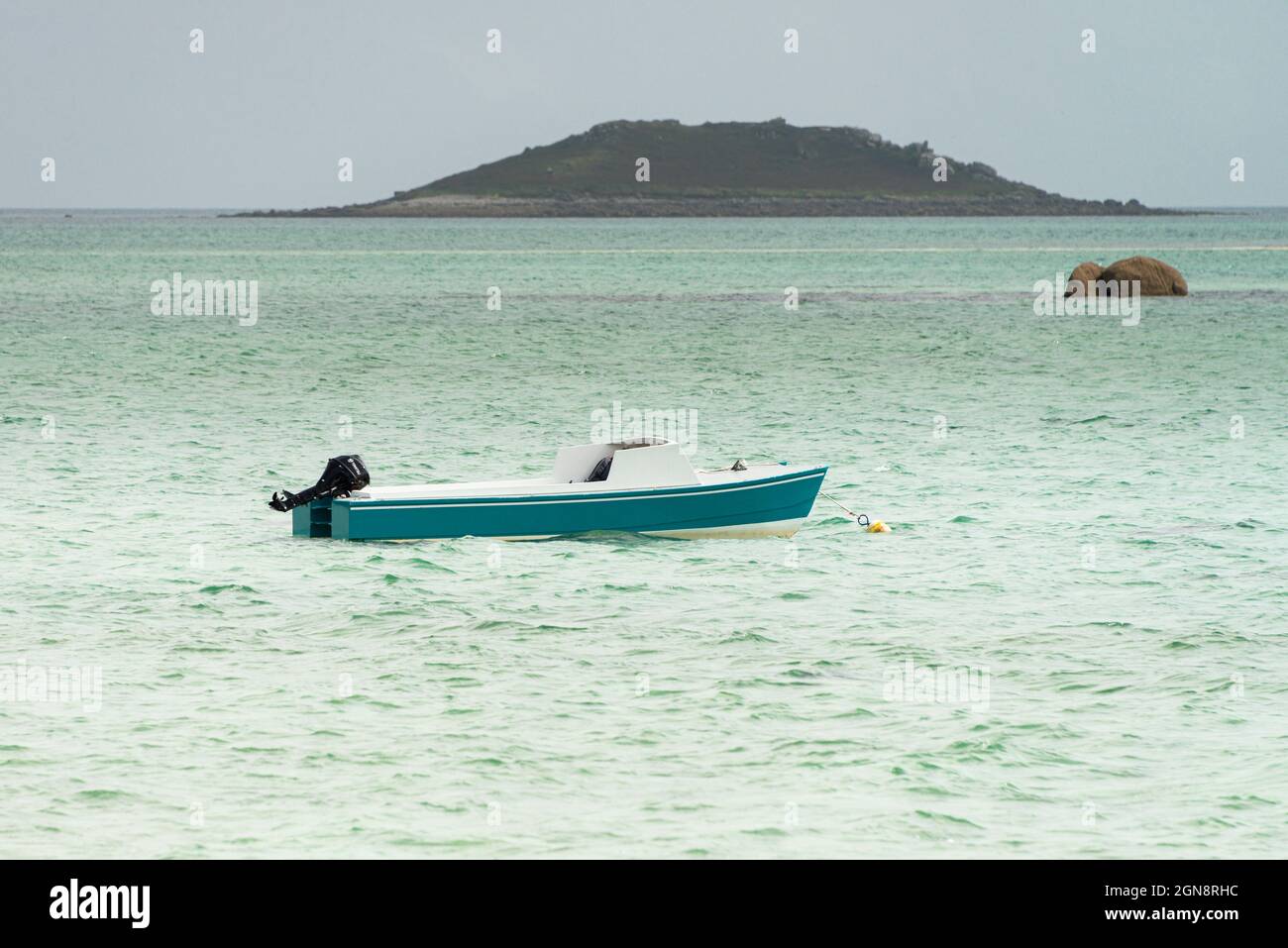 Un petit bateau bleu et blanc au large de la côte de St Martin, les îles de Scilly Banque D'Images