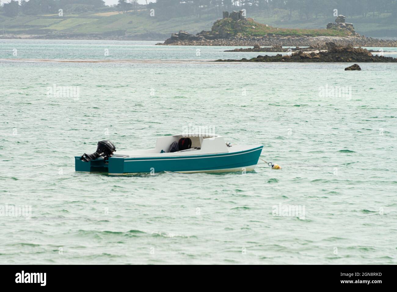 Un petit bateau bleu et blanc au large de la côte de St Martin, les îles de Scilly Banque D'Images