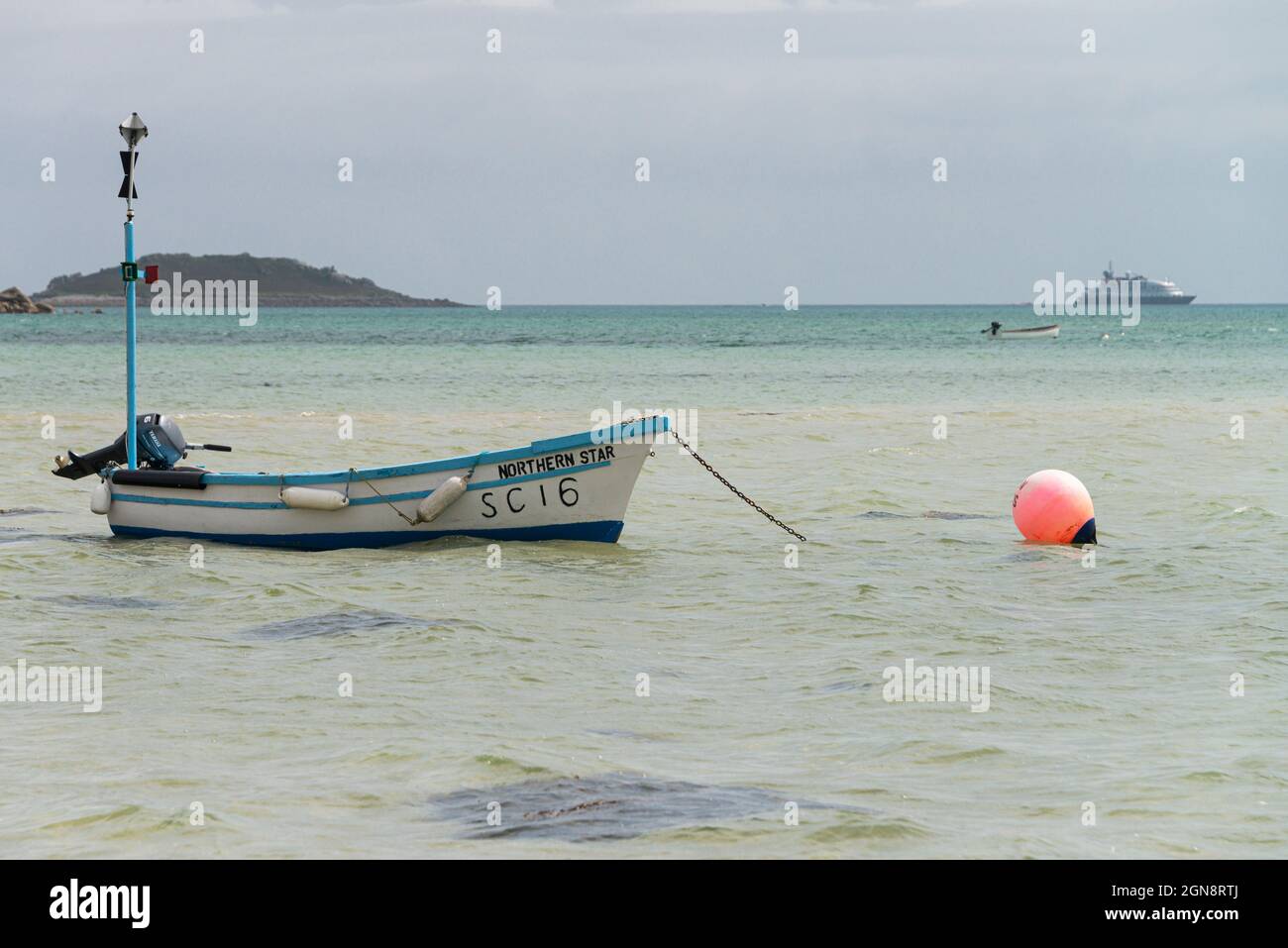 Un petit bateau bleu et blanc au large de la côte de St Martin, les îles de Scilly Banque D'Images