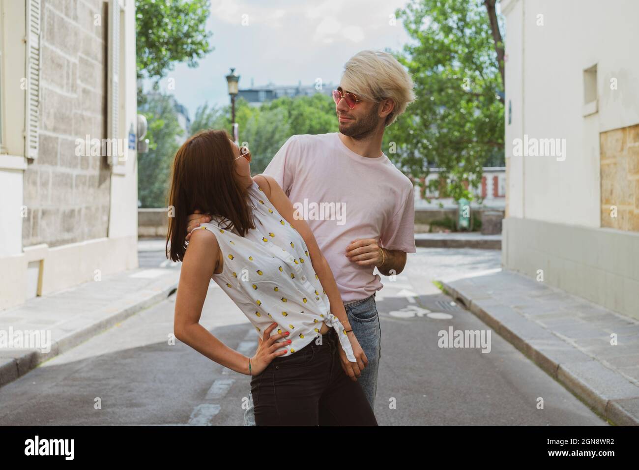 Un jeune homme gay et une jeune amie se regardant les uns les autres tout en se tenant dans la rue Banque D'Images