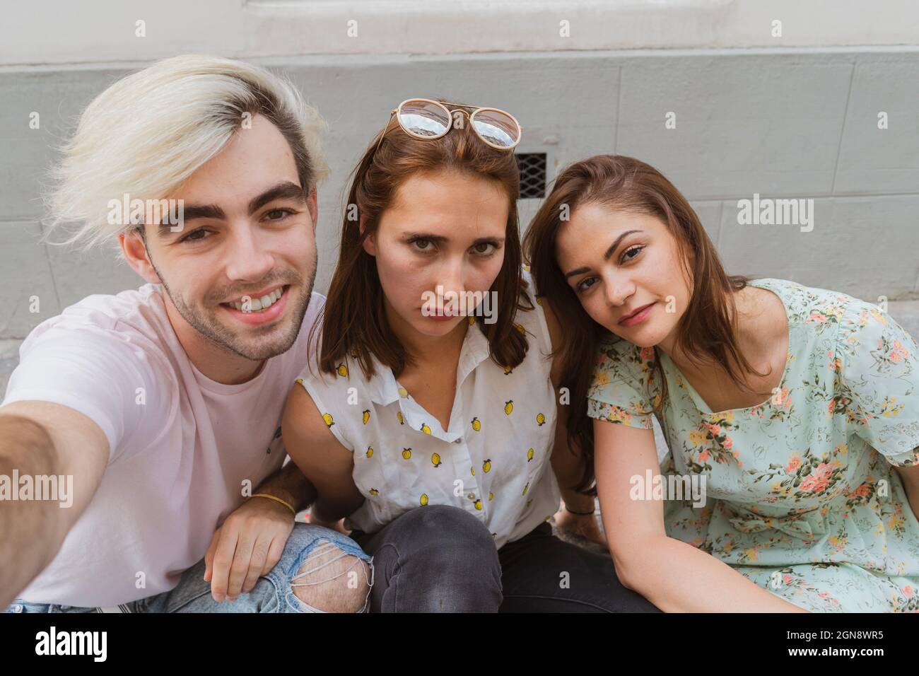 Amis hommes et femmes assis ensemble sur le sentier Banque D'Images