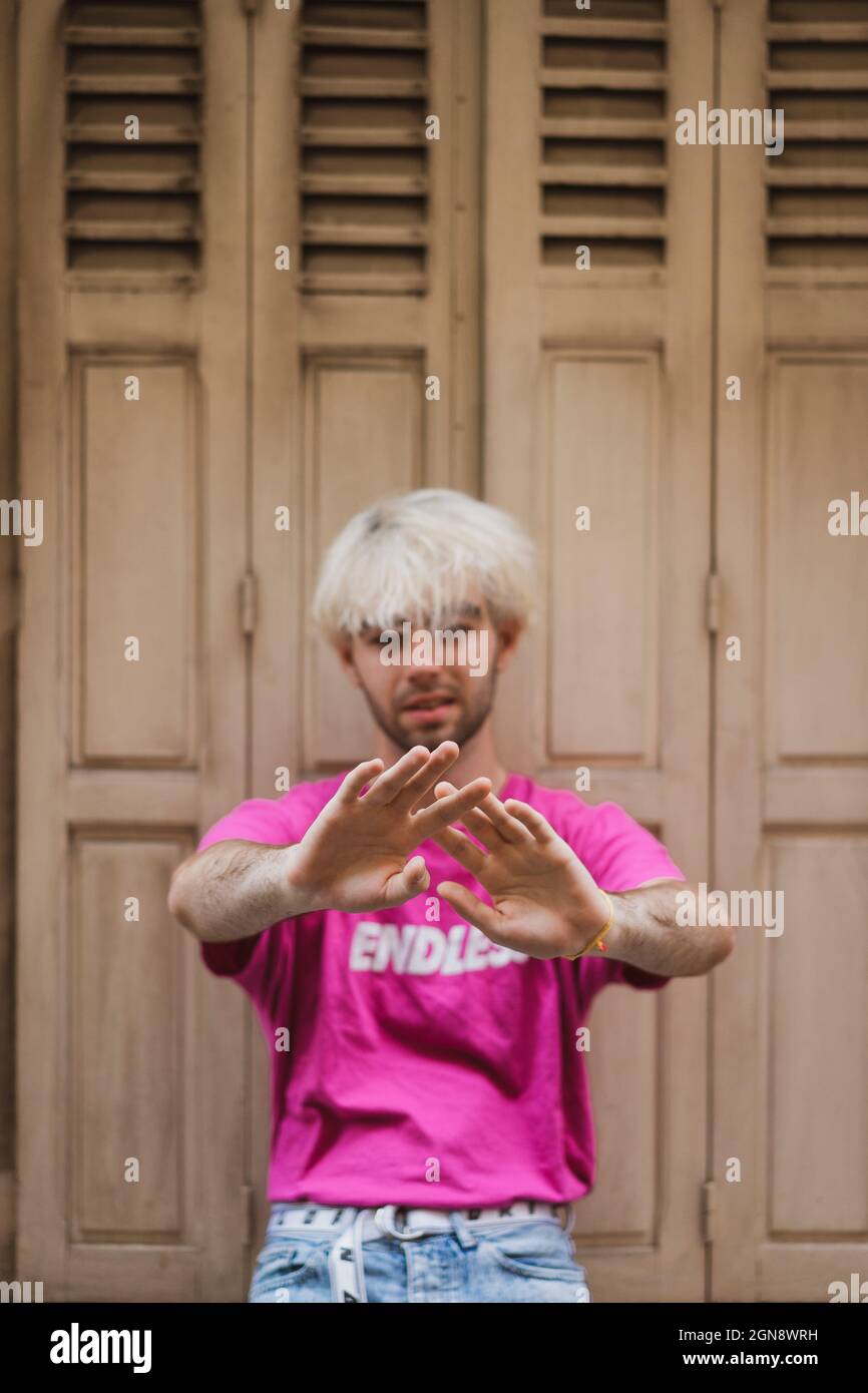 Gai homme en train de gesturer en se tenant devant la porte Banque D'Images