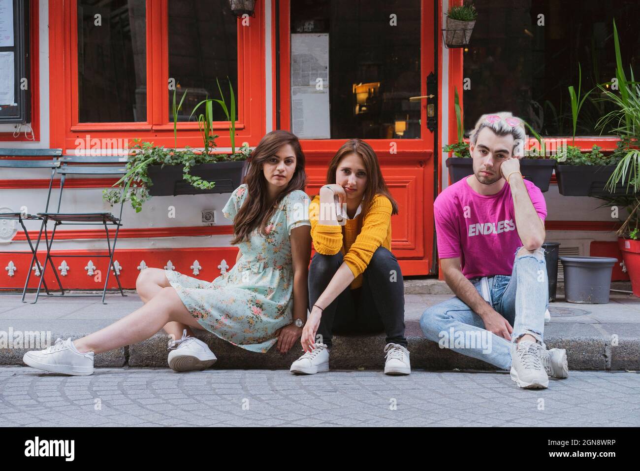 Des amis gays et des amis féminins assis ensemble sur une piste de marche Banque D'Images