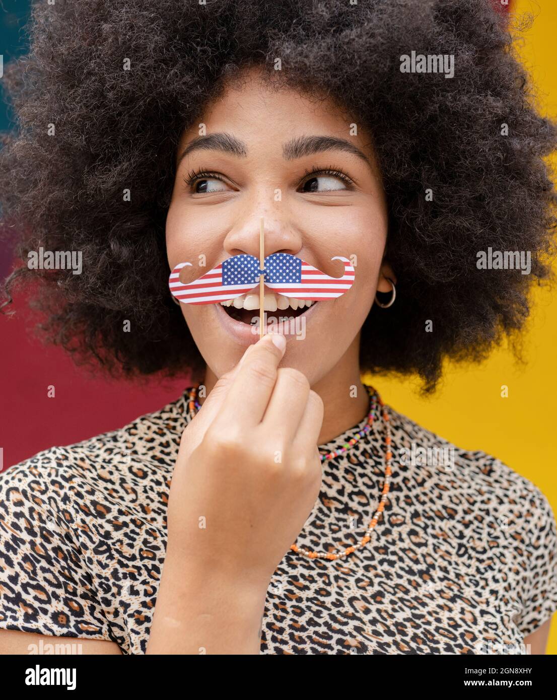 Femme regardant sur le côté tout en tenant le support de moustache Banque D'Images