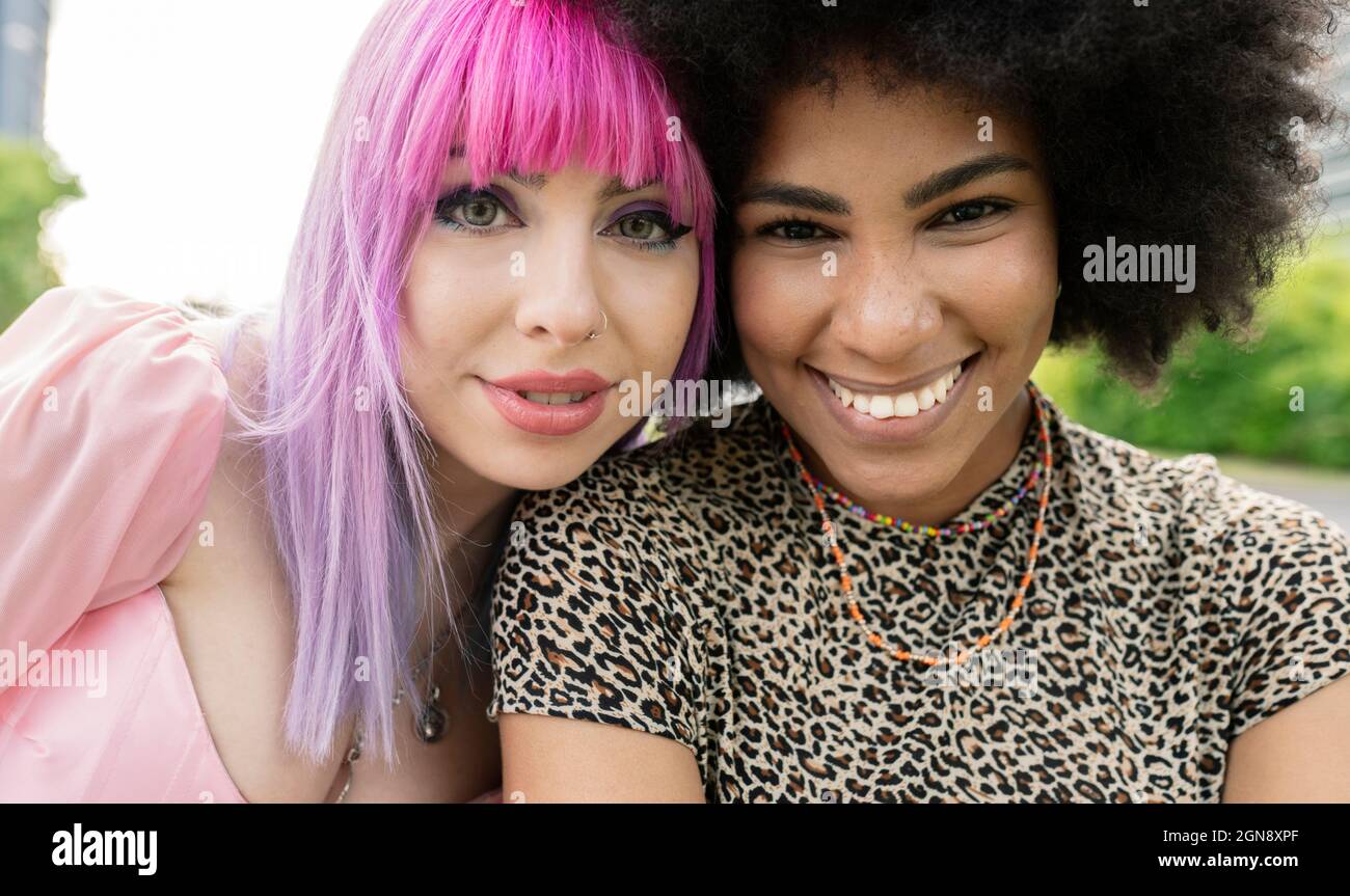 Des amies multiethniques souriant au parc Banque D'Images