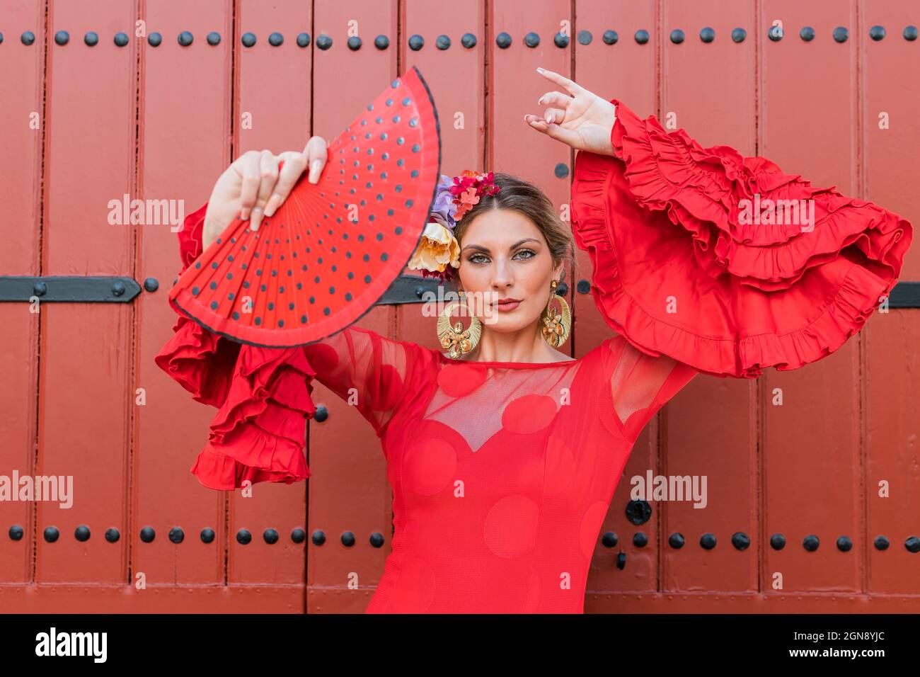 Danseuse de flamenco féminine dansant en face de la porte rouge Banque D'Images