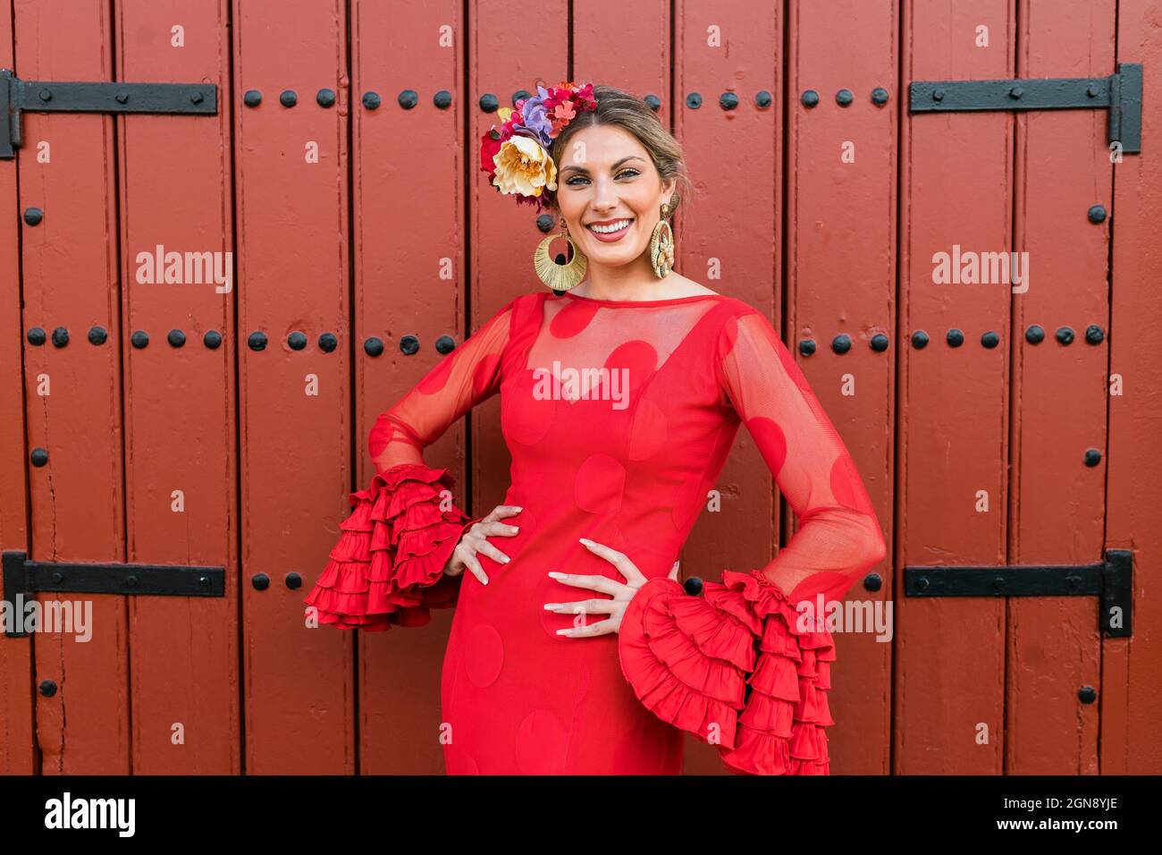 Danseuse de flamenco souriante devant la porte rouge Banque D'Images