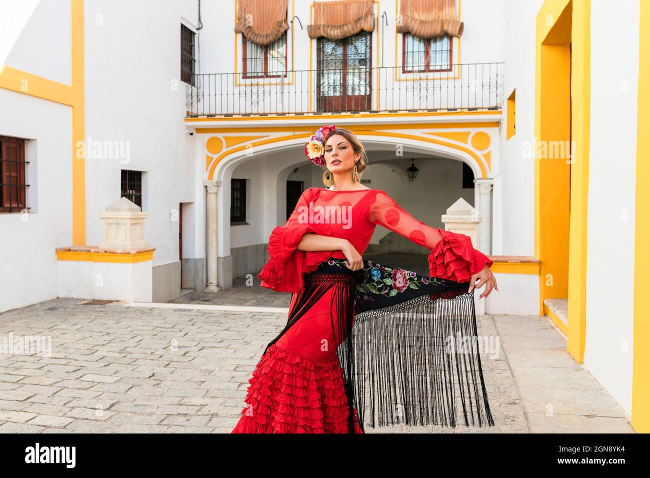 Danseuse debout devant la Plaza de toros de la Real Maestranza de Caballeria de Sevilla, Espagne Banque D'Images