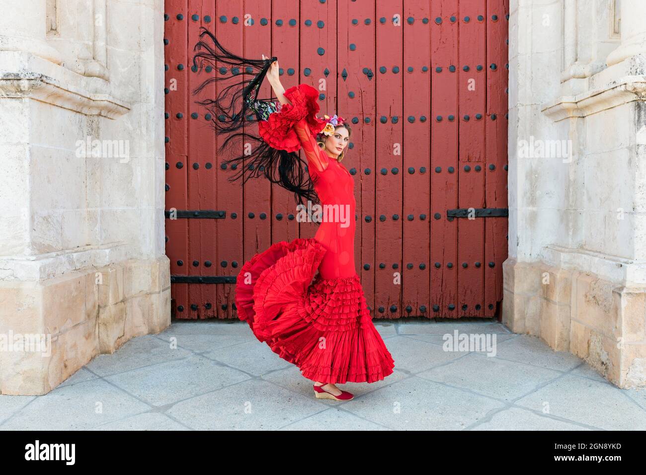 Danse flamenco féminine avec les mains soulevées par la porte Banque D'Images