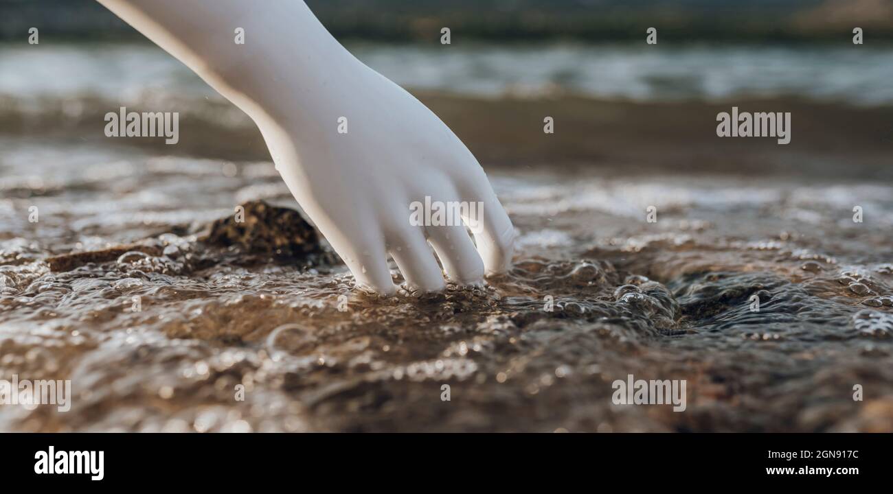 Robot avec main dans l'eau au bord du lac Banque D'Images