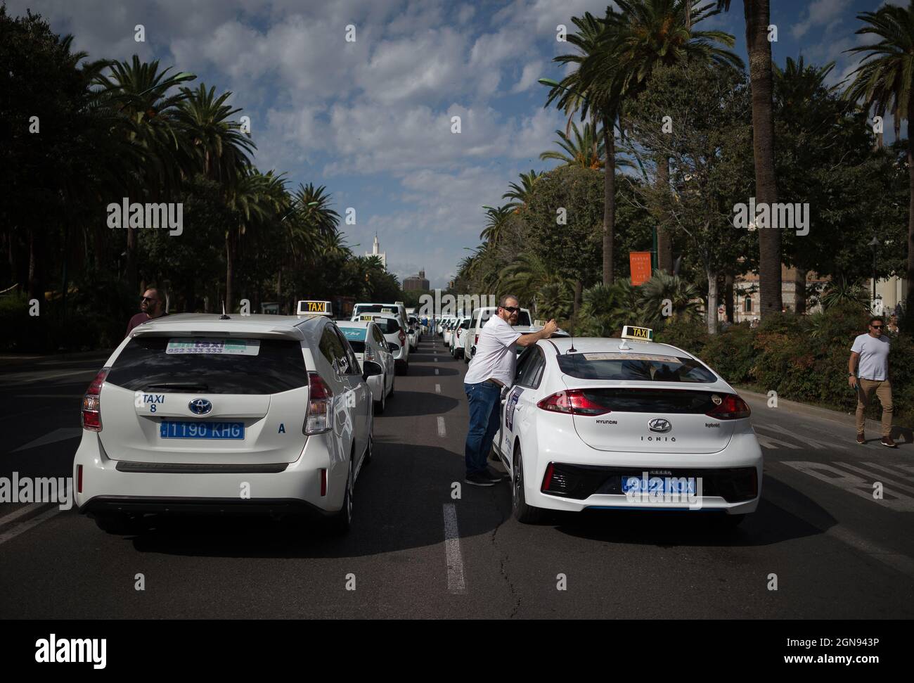 Malaga, Espagne. 23 septembre 2021. Un chauffeur de taxi se reposant entre deux taxis s'est arrêté alors qu'il participe à la manifestation.les chauffeurs de taxi ont défilé et bloqué les rues principales de Malaga exigeant un contrôle plus élevé sur les véhicules avec permis de conduire (VTC). Malaga est la ville d'Andalousie où il y a plus de licences de voitures VTC. (Photo de Jesus Merida/SOPA Images/Sipa USA) Credit: SIPA USA/Alay Live News Banque D'Images