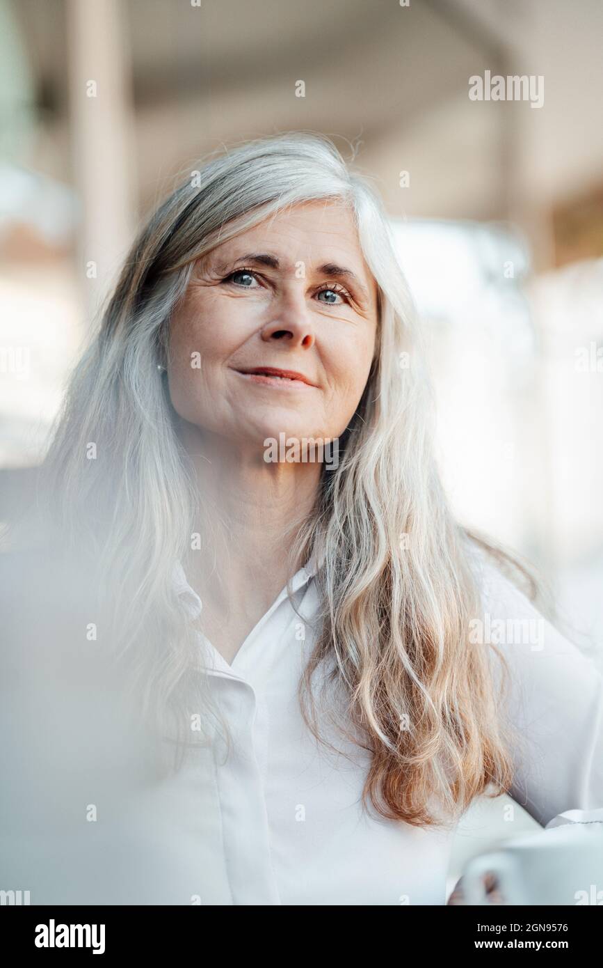 Femme mûre souriante au café Banque D'Images
