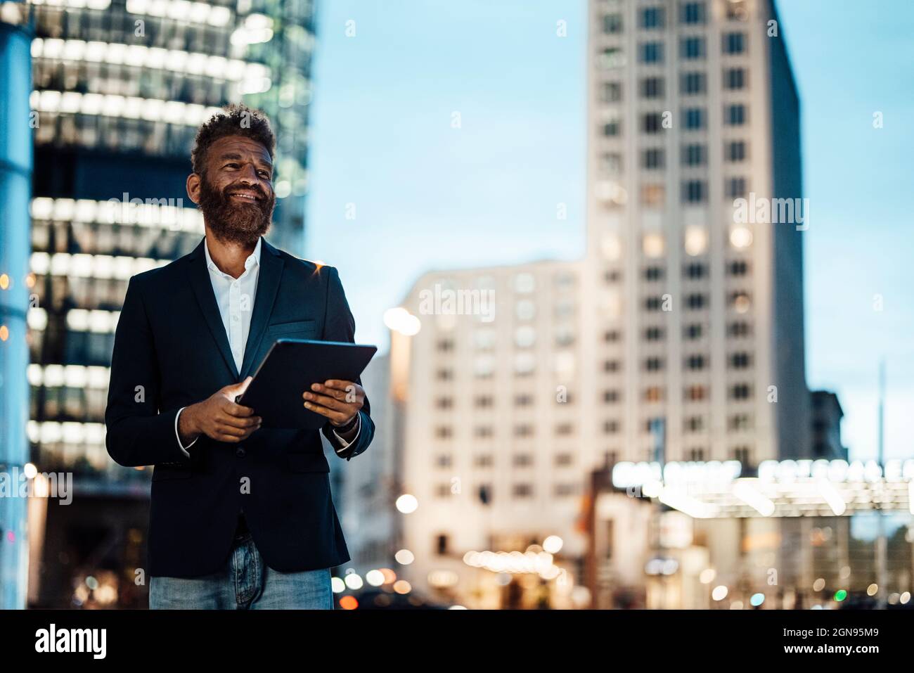 Homme souriant travailleur indépendant avec une barbe tenant une tablette numérique Banque D'Images