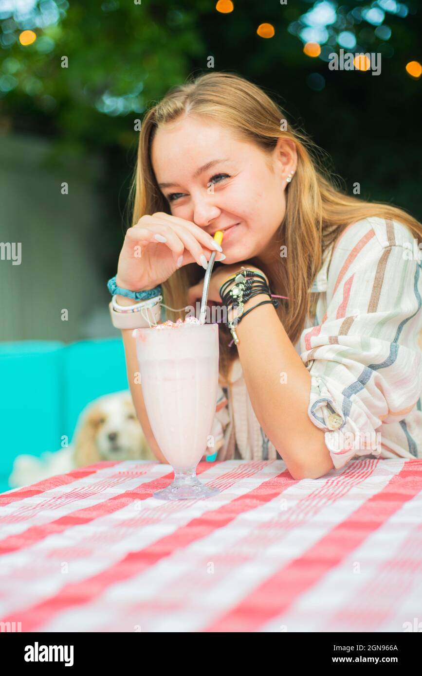 Portrait d'arrière-cour d'une fille qui boit un milkshake Banque D'Images
